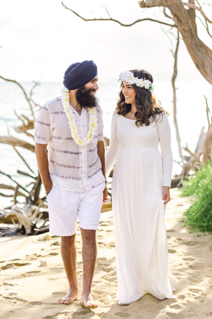 Couple with lei on beach for sunset maternity babymoon photography
