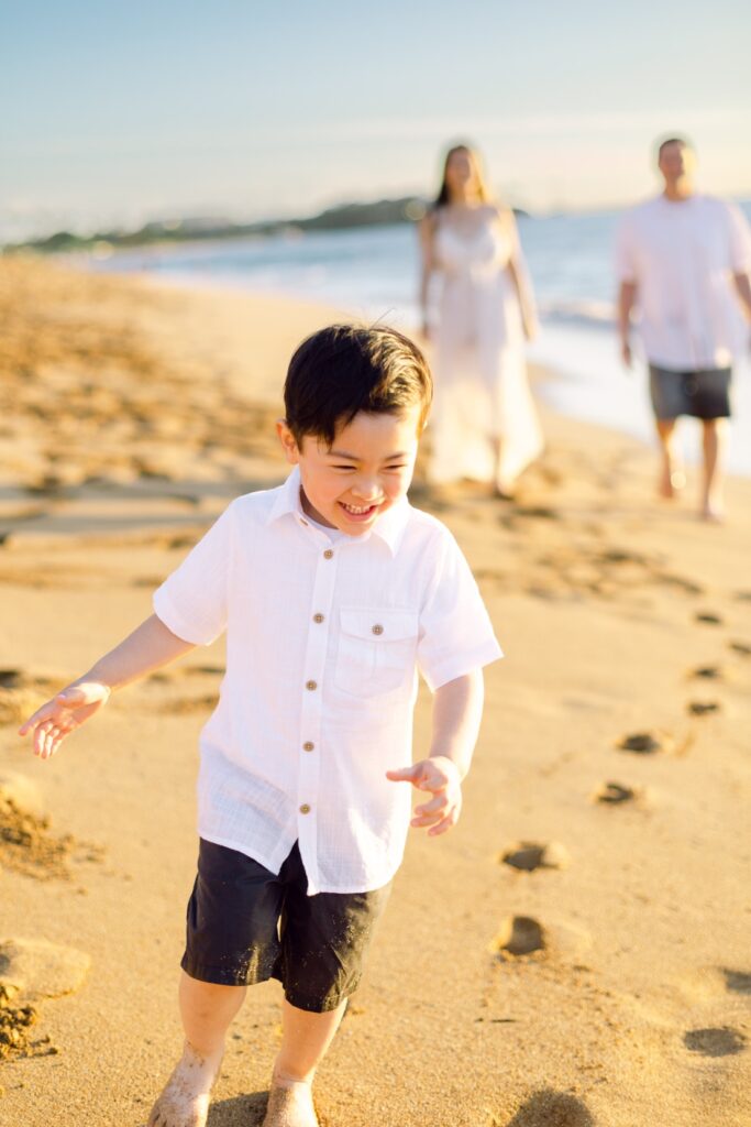 Boy having fun running at beach at Kahekili Beach Maui family photo session
