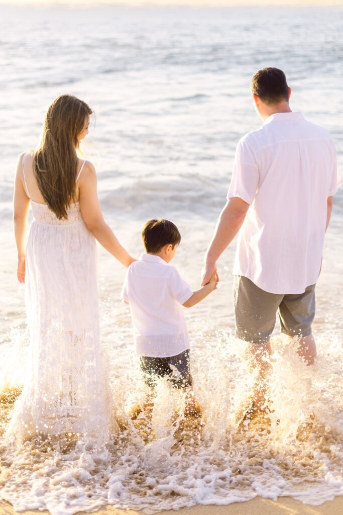 family splashing in the waves for family photos in Kaanapali Maui