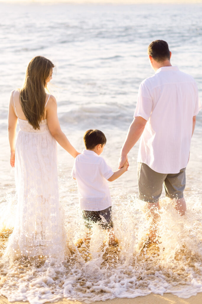 Kahekili Beach park sunset family photo shoot family holding hands in waves 