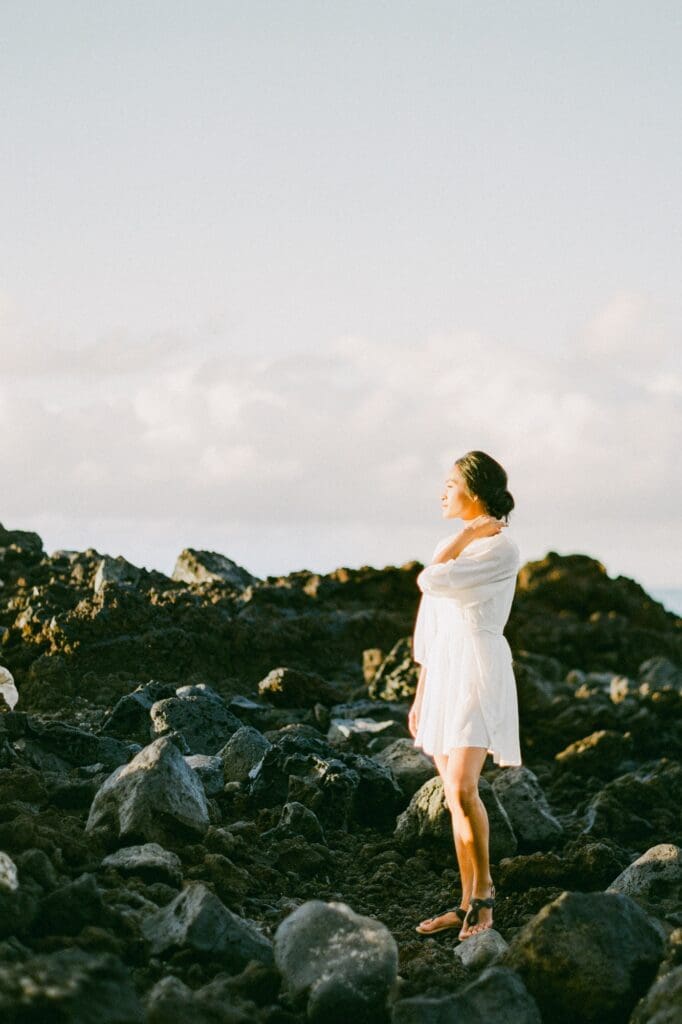 Maternity photography at La Pérouse Bay featuring black lava rocks and turquoise ocean waves, a dramatic Maui maternity photo location.
