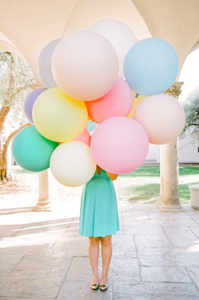 Maui maternity photos of happy pregnant woman surrounded by big round pastel balloons