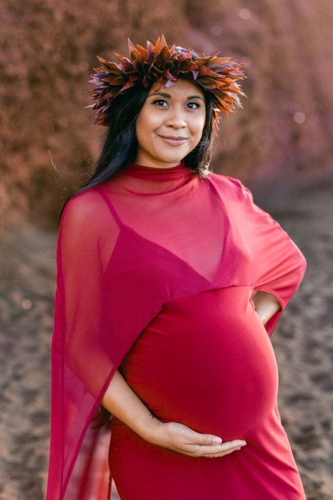 pregnant woman on Maui black sand beach during babymoon maternity photos