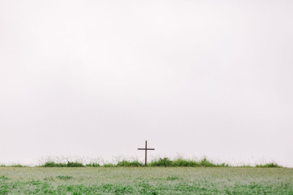 cross standing on field in front of mist on maui