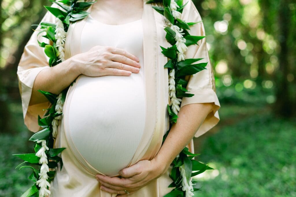 Close-up maternity portrait with maile and tuberose lei in Honolua Bay rainforest