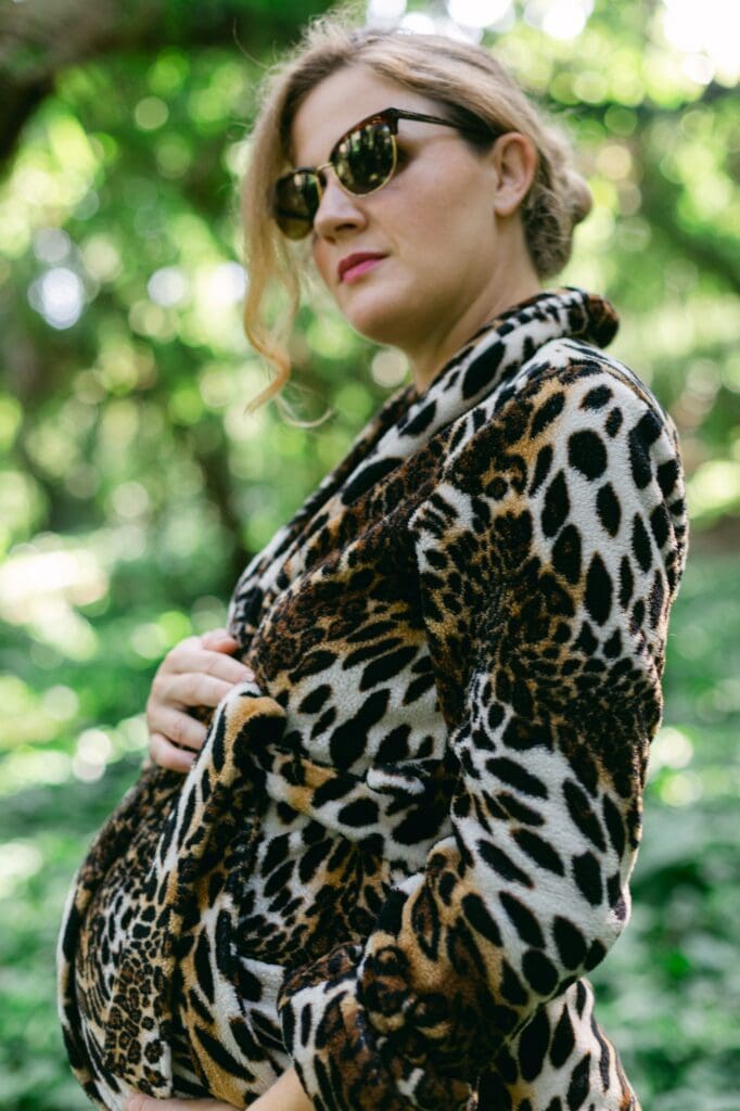 Maui maternity photo shoot in a leopard robe and sunglasses surrounded by rainforest vines at Honolua