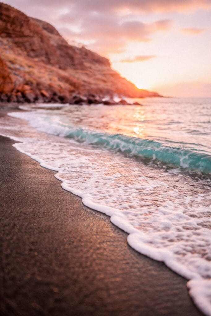 sunset over Maui's black sand beach Oneuli