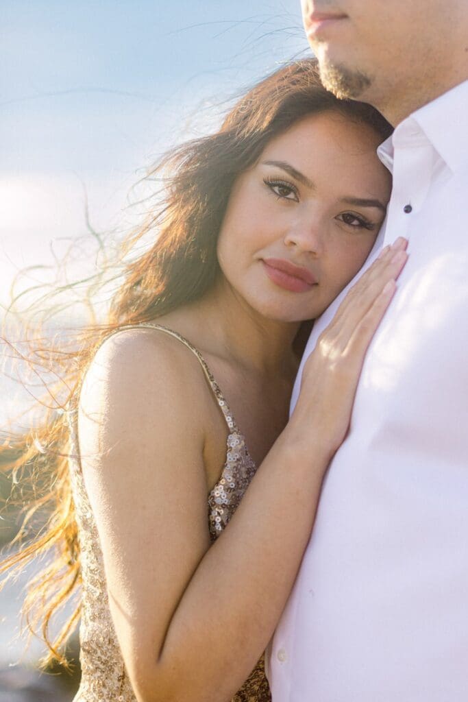 An intimate, close-up maternity portrait of a woman at sunset, featuring the sculptural limestone of Dragon’s Teeth Maui in the background.