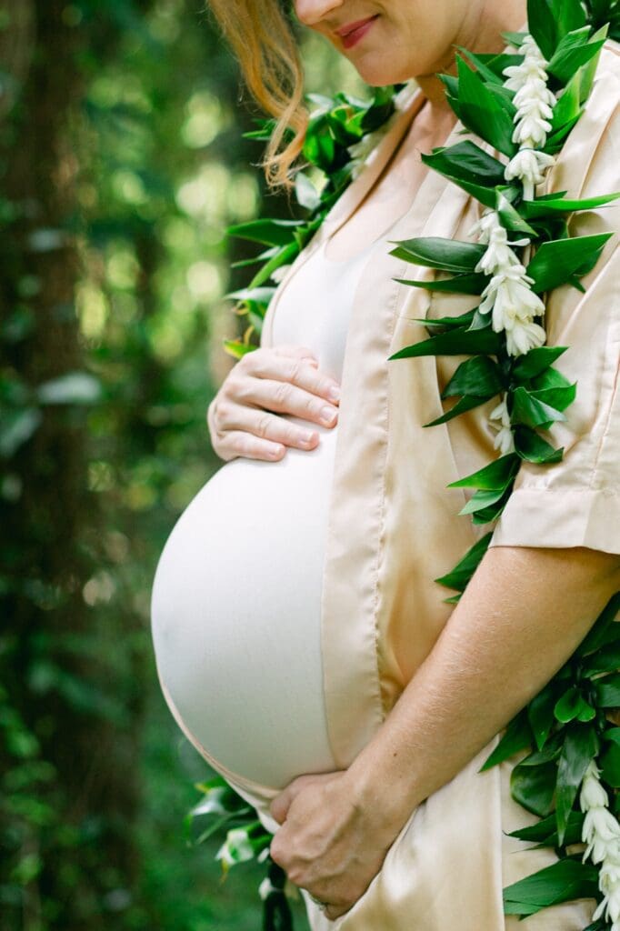 Close up of hapai lei of ti and tuberose and belly for Maui maternity photos at Honolua Bay
