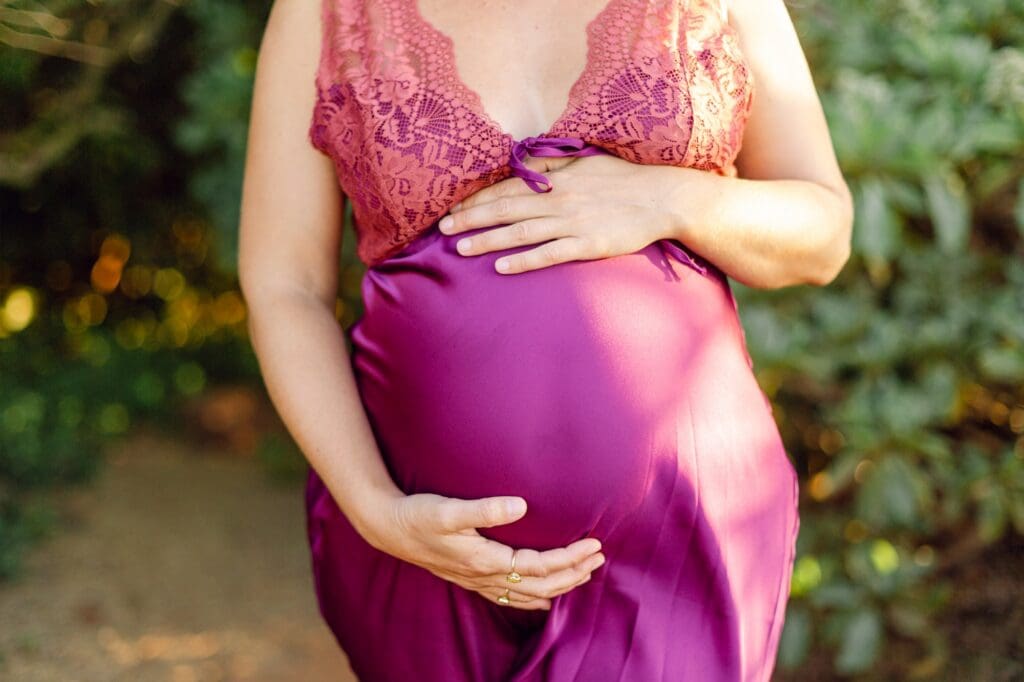 close-up of baby bump with flowing dress detail in Maui maternity session