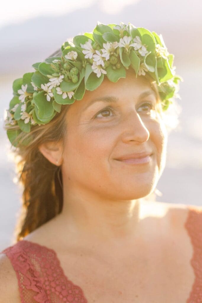sunwashed close-up maternity portrait of woman looking at sky with naupaka lei on Maui