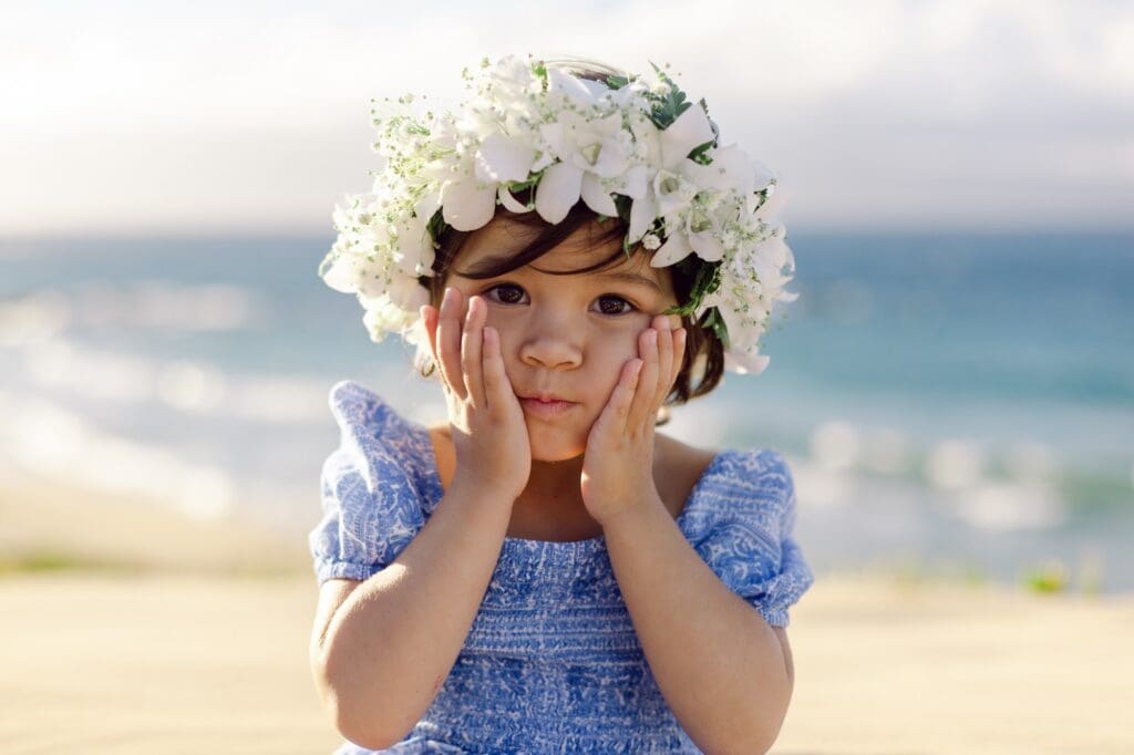 older sister at beach with white flower crown for family reunion