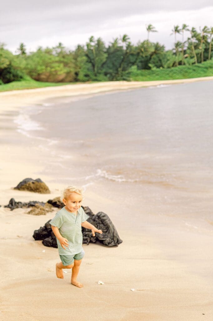 toddler running to mama during Maui maternity session with sibling
